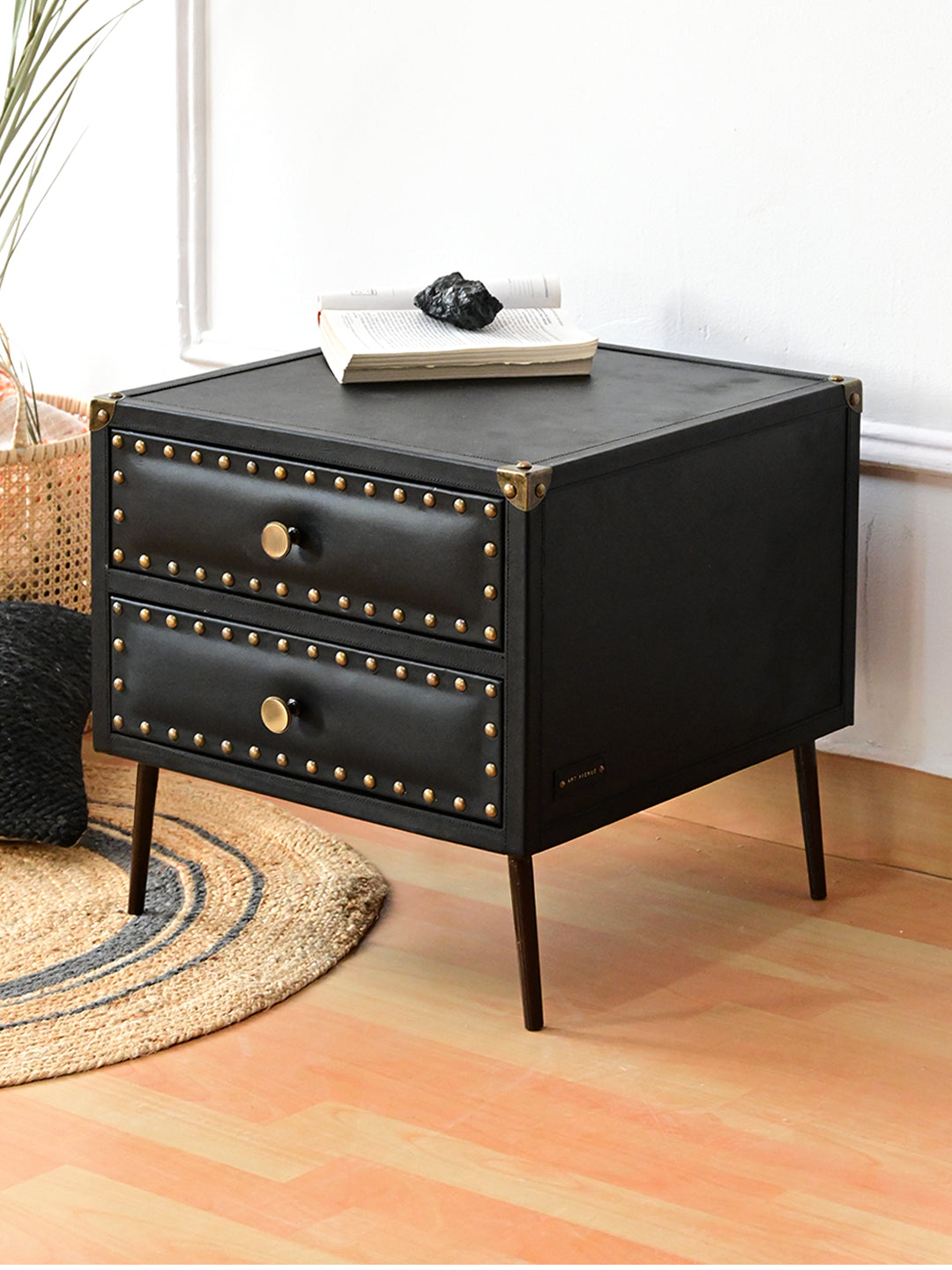 Kishangarh bedside table in Onyx leather, three-quarter styled view beside a cane basket, Art Avenue