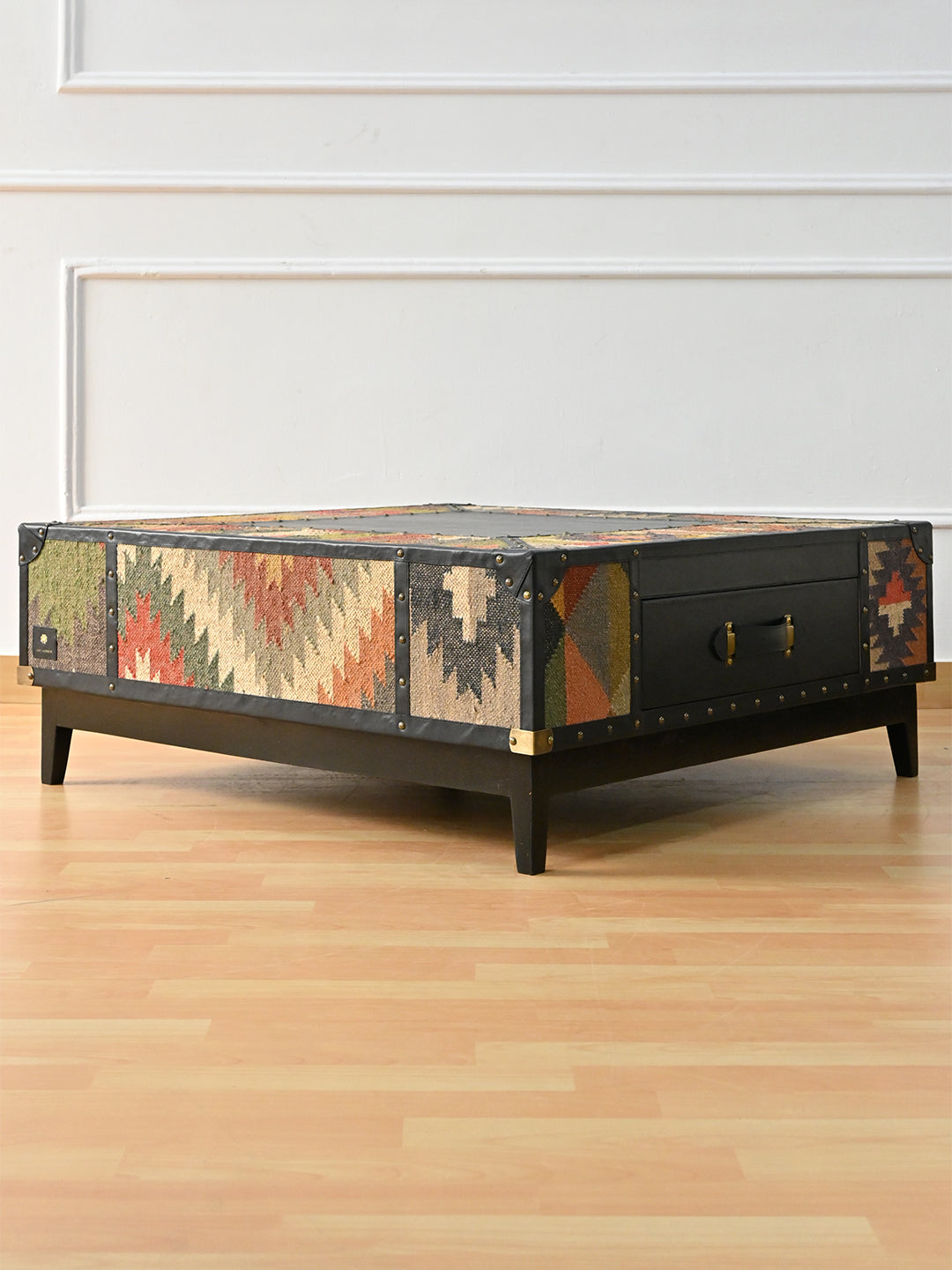 Mehrangarh kilim trunk coffee table in black Onyx leather by Art Avenue, three-quarter view showing the drawer front and kilim sides, made to order
