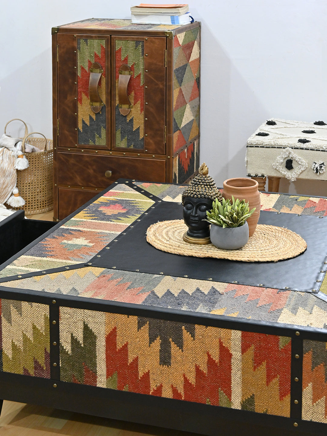 Close styled view of the Mehrangarh coffee table top with a kilim and leather cabinet behind, Art Avenue