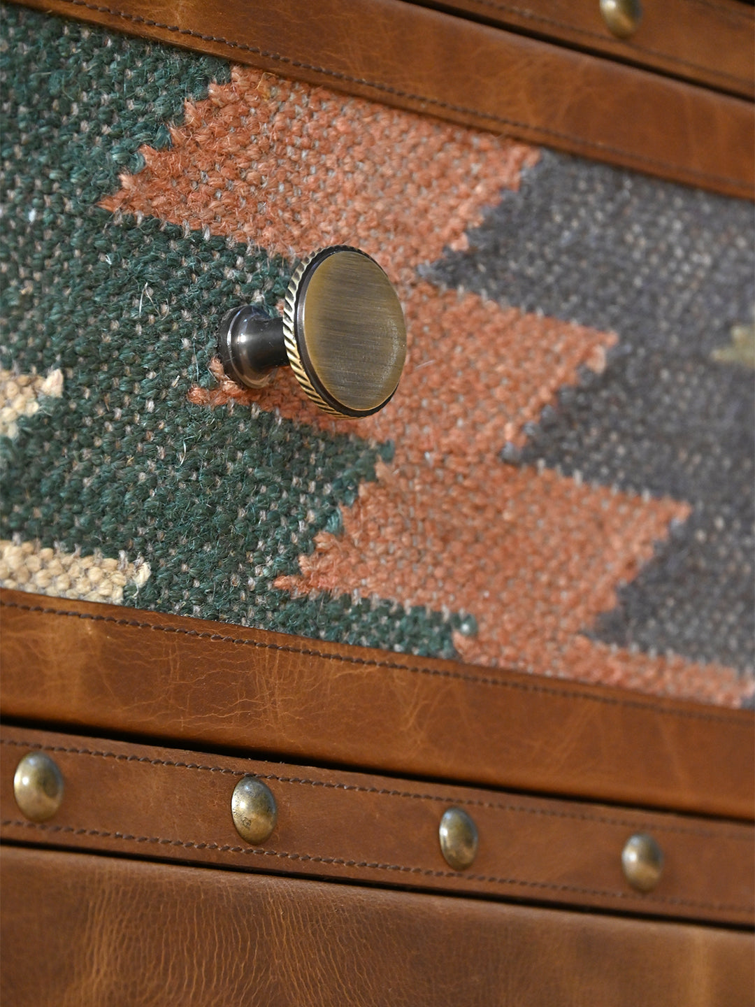 Close detail of a rope-edge antique-brass knob on the kilim drawer of the Kanota sideboard by Art Avenue