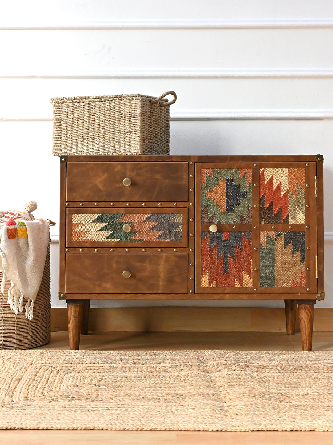 Kanota kilim and leather sideboard by Art Avenue styled with a woven basket on top and a jute rug