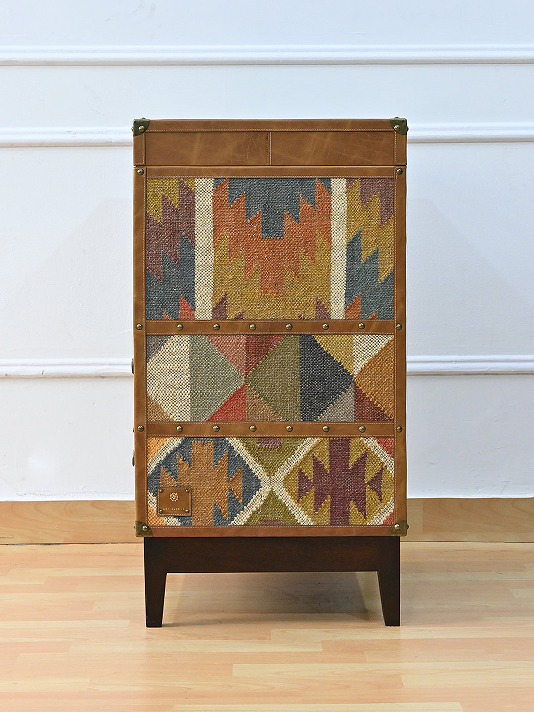 Back of the Osian trunk, faced entirely in vintage kilim with leather binding and the Art Avenue maker's tab at the base. Made to order.