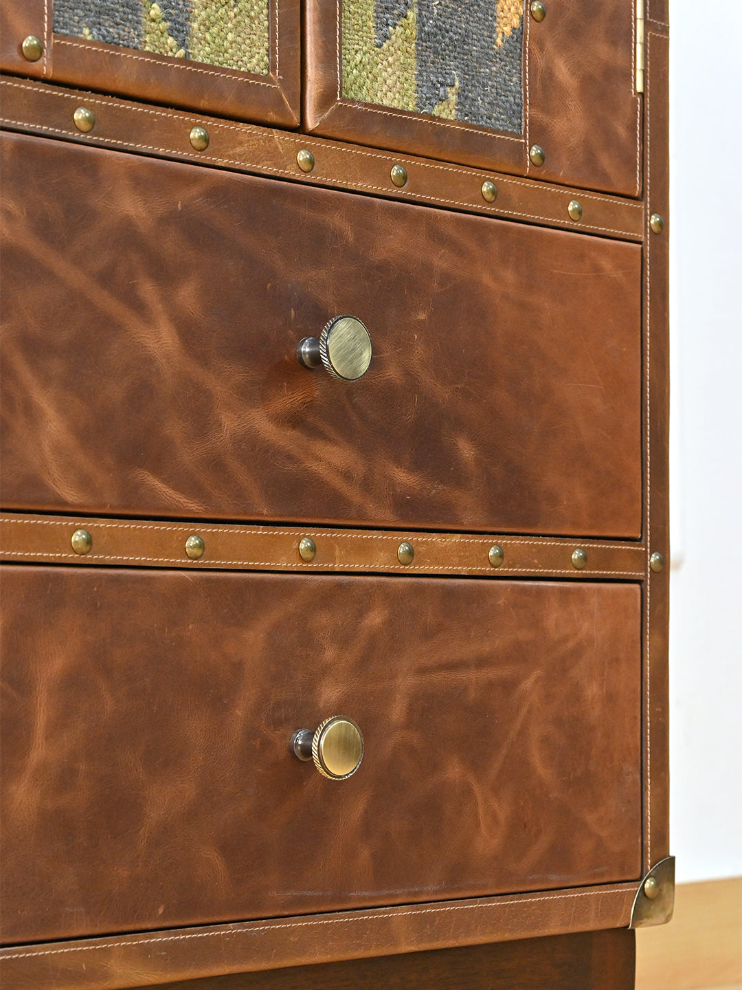 Detail of the two leather drawer fronts with knurled brass knobs and hand-driven studs — Art Avenue Shalimar cabinet